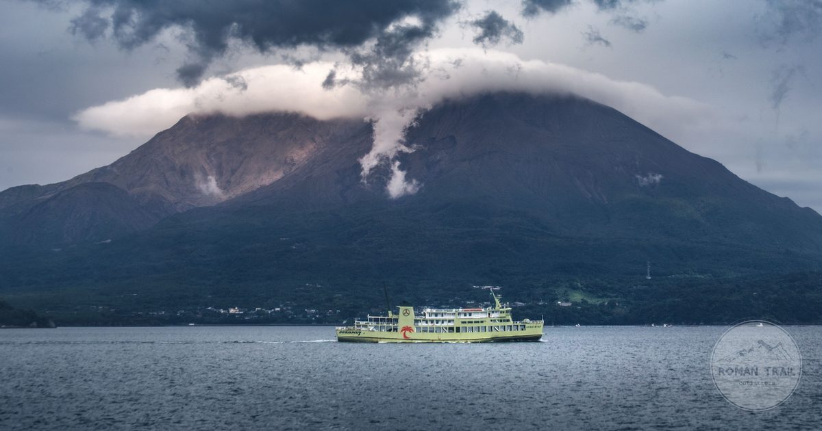A ferry sailing near Sakurajima volcano under heavy cloud, Kagoshima, Japan
