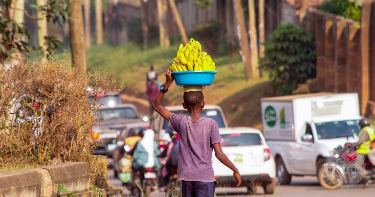 A street vendor carrying a basket of bananas in Kampala, Uganda