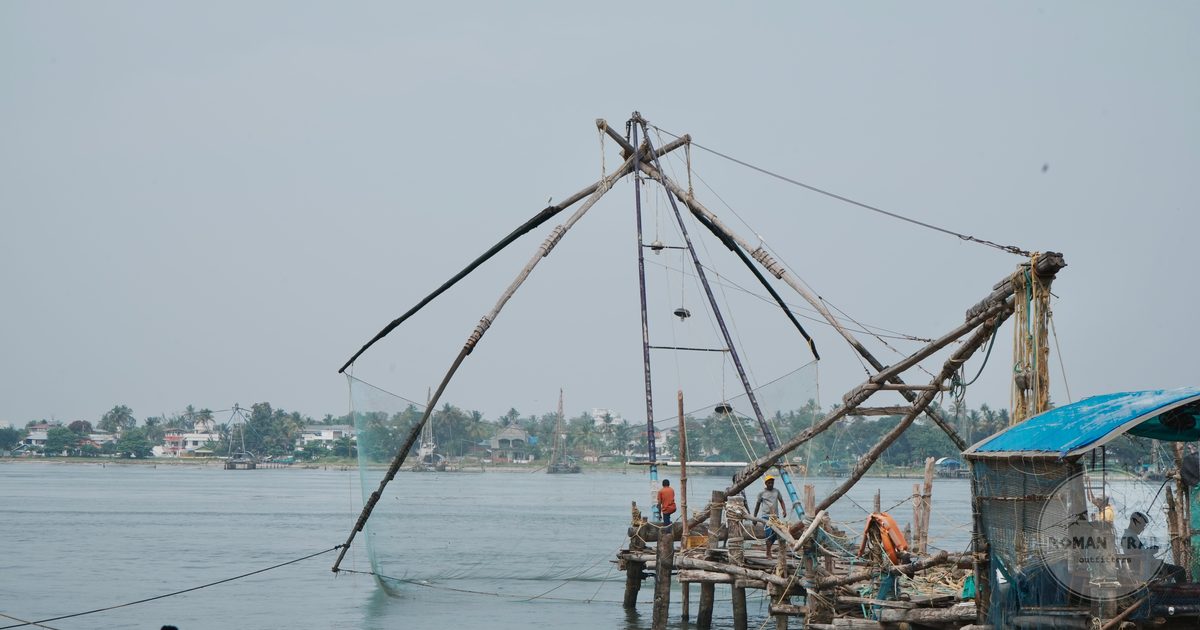 Fishermen working the Chinese fishing nets at Kochi, Kerala, India