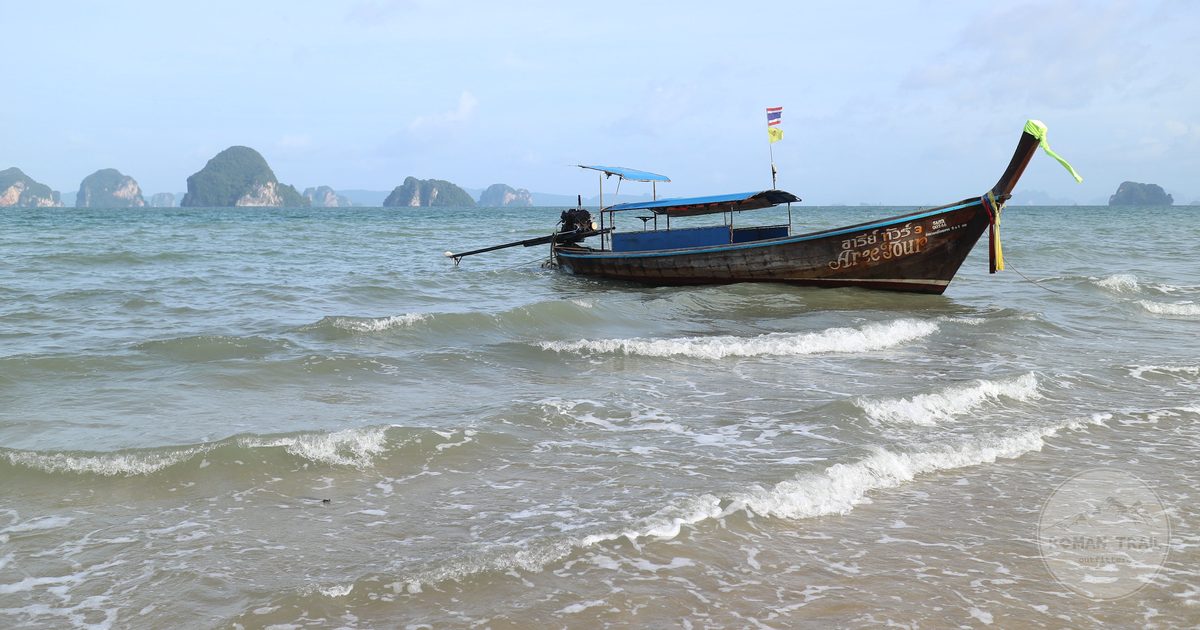 A longtail boat below limestone cliffs in Krabi, Thailand