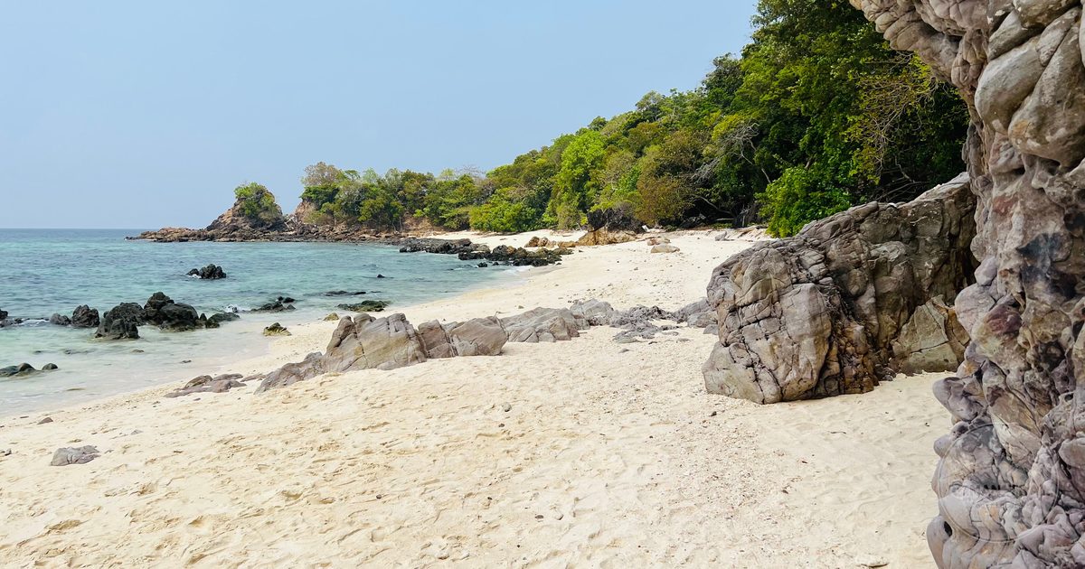 A sandy beach and rocky cliffs on Ko Tarutao, Satun, Thailand