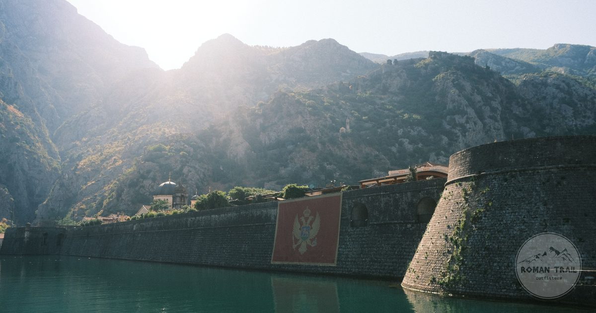The fortress above Kotor lit by sun and framed by mountains, Montenegro