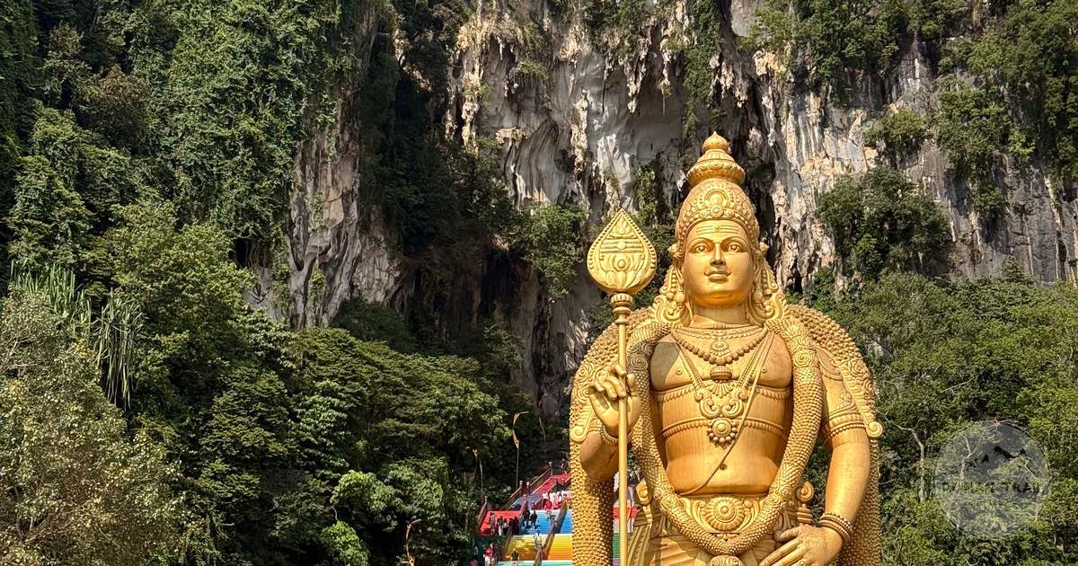 The golden Lord Murugan statue below the limestone cliff at Batu Caves, Kuala Lumpur for women travelers