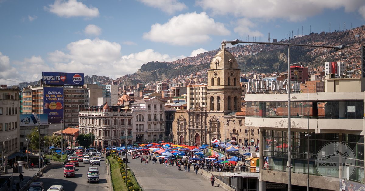 A busy street market below colonial era buildings in central La Paz, La Paz packing list for women by Roman Trail Outfitters