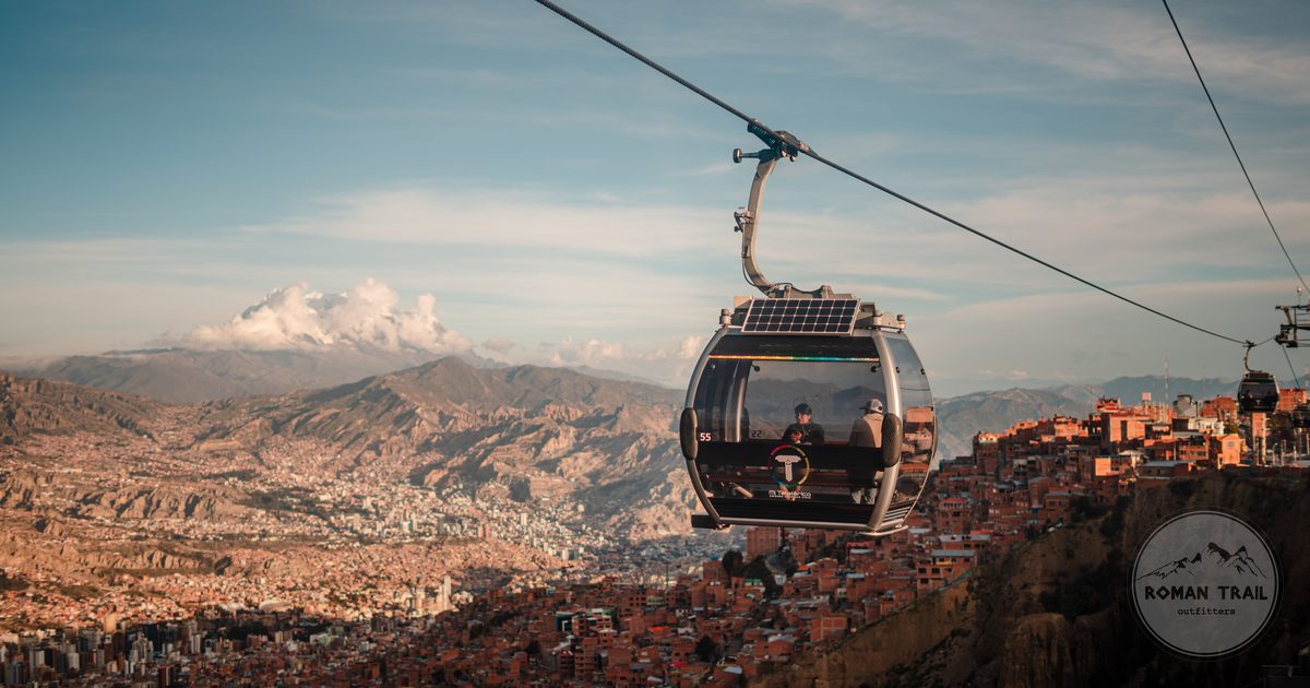 Cable cars of the Mi Teleferico network crossing above La Paz at sunset, La Paz packing list for women by Roman Trail Outfitters