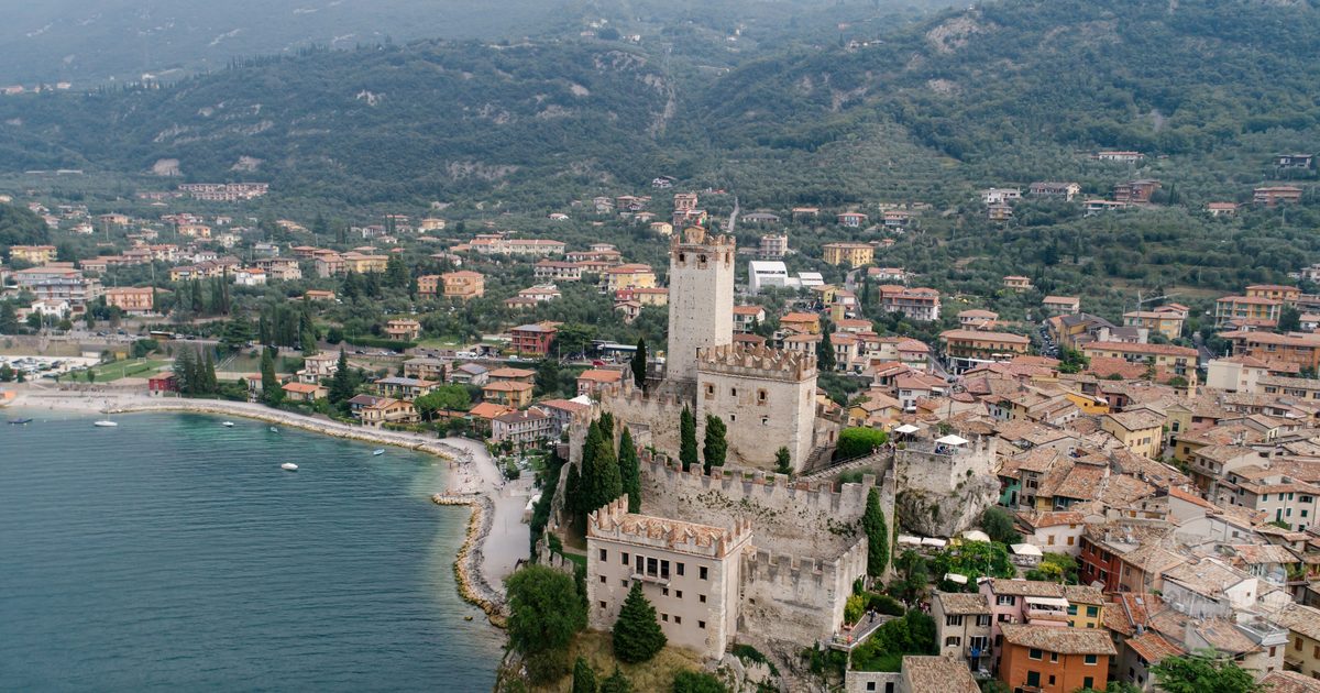 Malcesine castle above the water on the eastern shore of Lake Garda, Lake Garda packing list for women by Roman Trail Outfitters