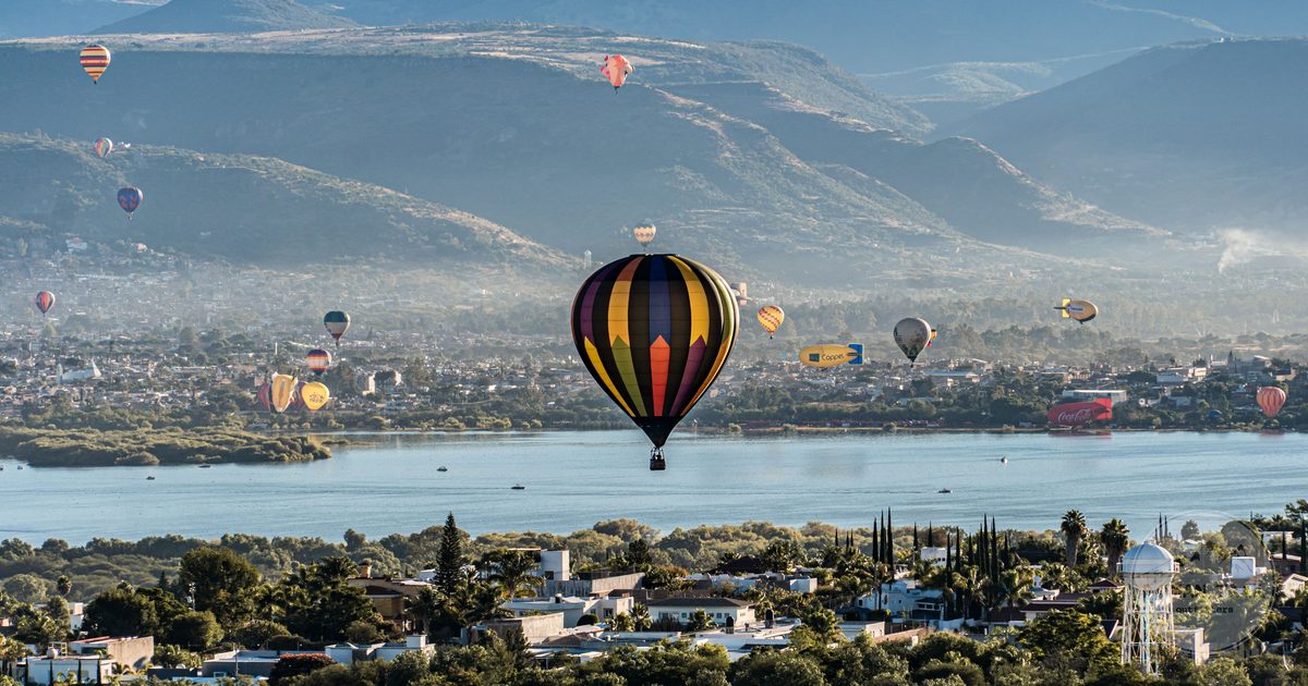 Hot air balloons over Leon, Mexico with mountains and a lake beyond