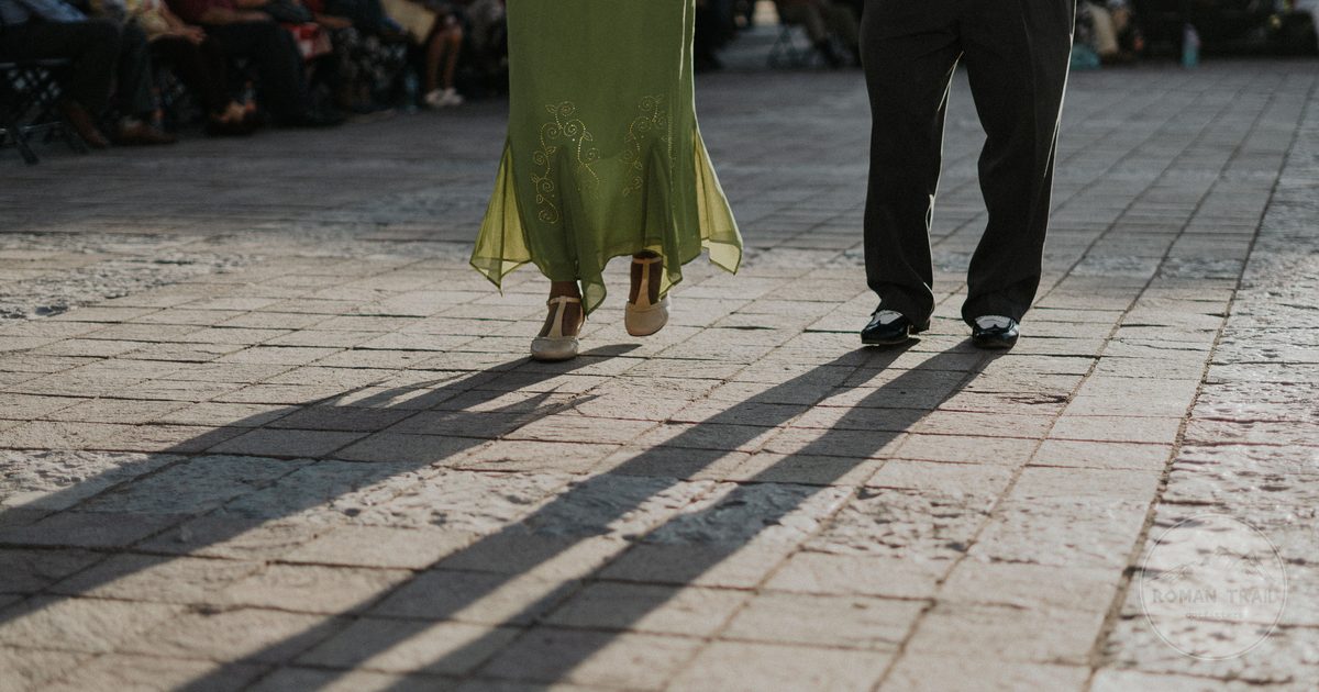 A couple dancing on a sunlit pavement in Leon, Mexico