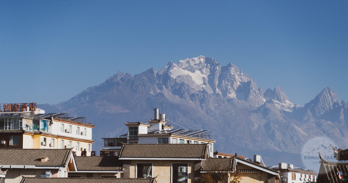 Traditional rooftops of Lijiang against snow capped mountains, Yunnan China