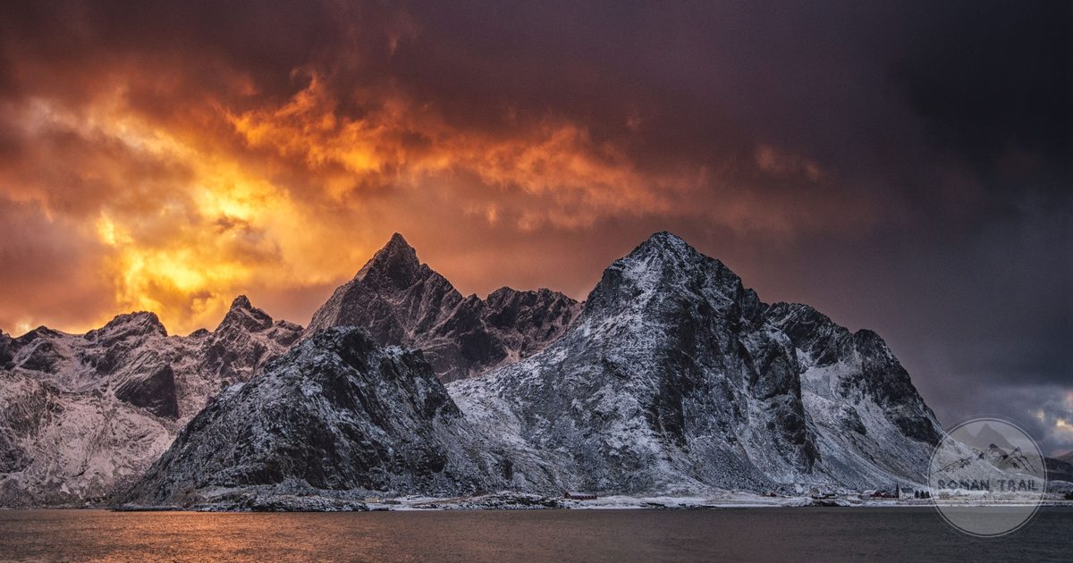 Orange sunset over snow-covered mountains in Nordland, Norway