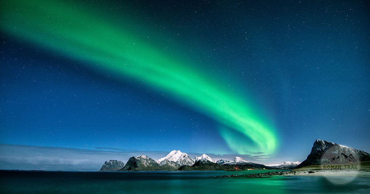 Northern Lights over snow-capped mountains in the Lofoten Islands, Norway