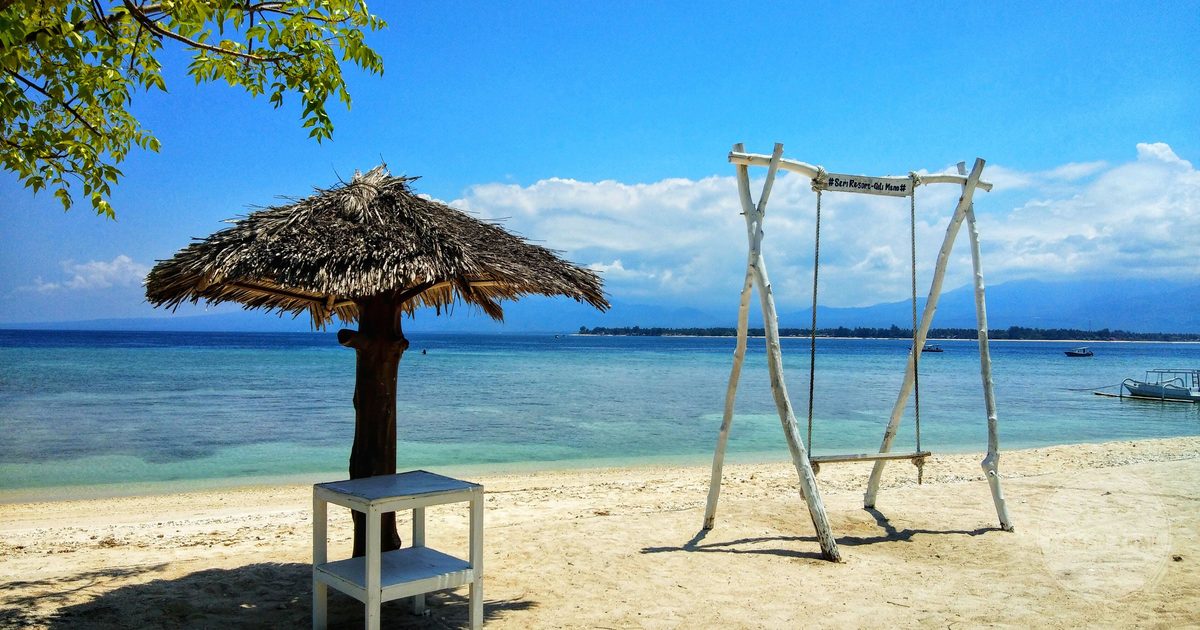 A beach swing and thatched umbrella in West Nusa Tenggara, Indonesia