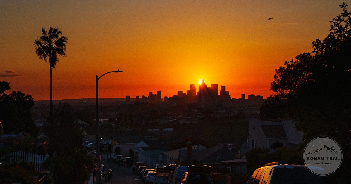 Sunset over the downtown Los Angeles skyline with palm trees, Los Angeles travel guide for women by Roman Trail Outfitters