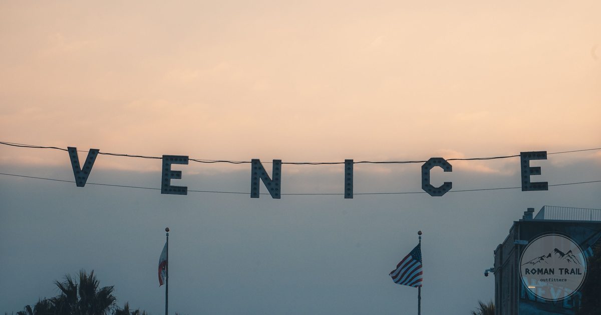 Venice Beach sign at sunset with palm trees, Los Angeles for women travelers