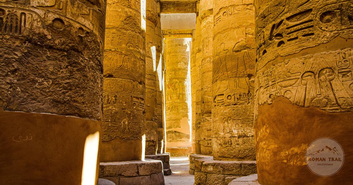 Sunlit hypostyle columns covered in hieroglyphs at Karnak temple in Luxor, Luxor packing list for women by Roman Trail Outfitters