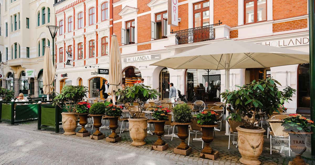 A café terrace with coloured facades and outdoor seating in Malmö, Sweden