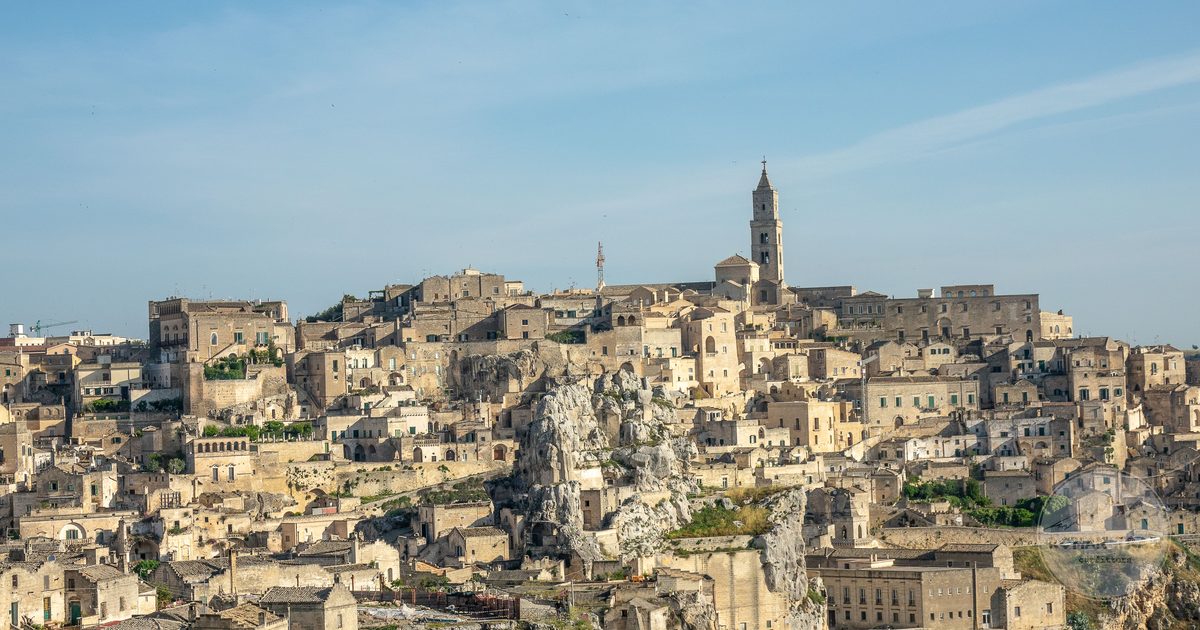 Panorama of Matera's ancient cave architecture under a wide sky, Matera packing list for women by Roman Trail Outfitters