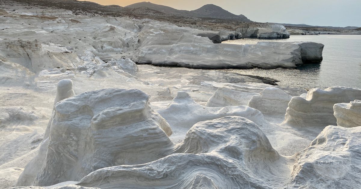 Pale eroded rock and clear water at Sarakiniko on Milos, Milos packing list for women by Roman Trail Outfitters