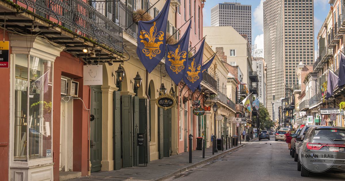 French Quarter street lined with historic buildings and fleur de lis flags, New Orleans for women travelers