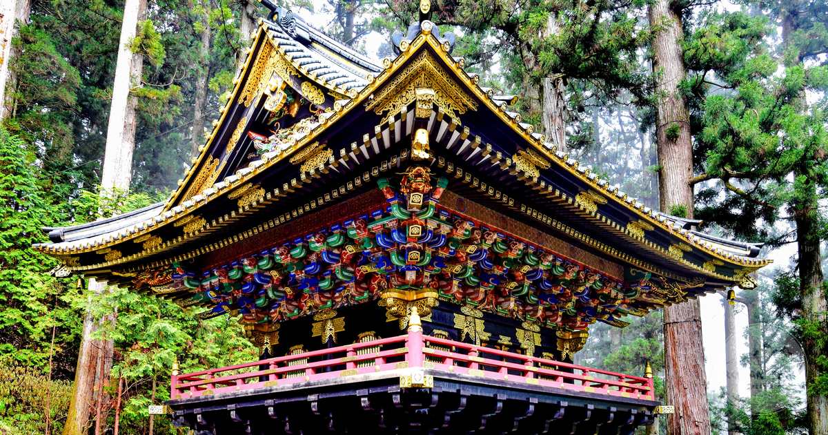 An ornate temple among towering cedar trees at Nikko, Japan
