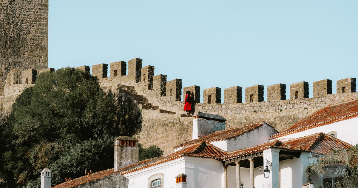 The historic walls and whitewashed buildings of Obidos under clear sky, Portugal