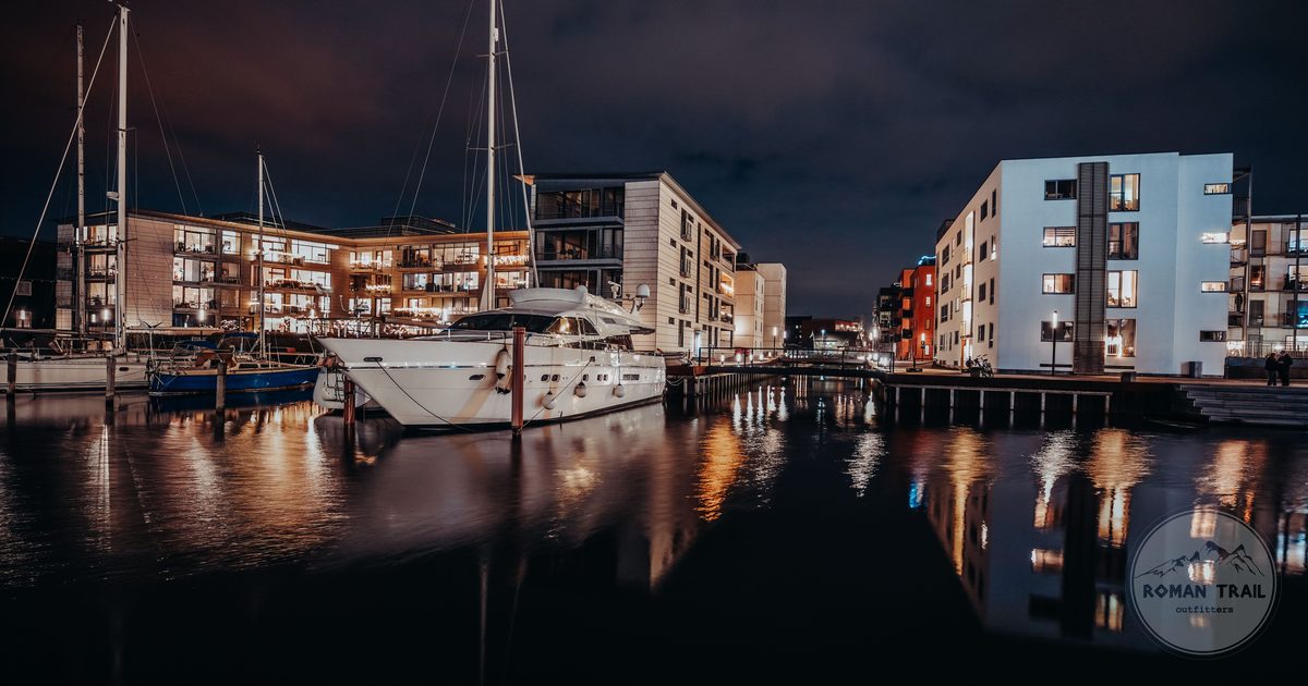 Odense marina at night with illuminated buildings and moored boats, Denmark
