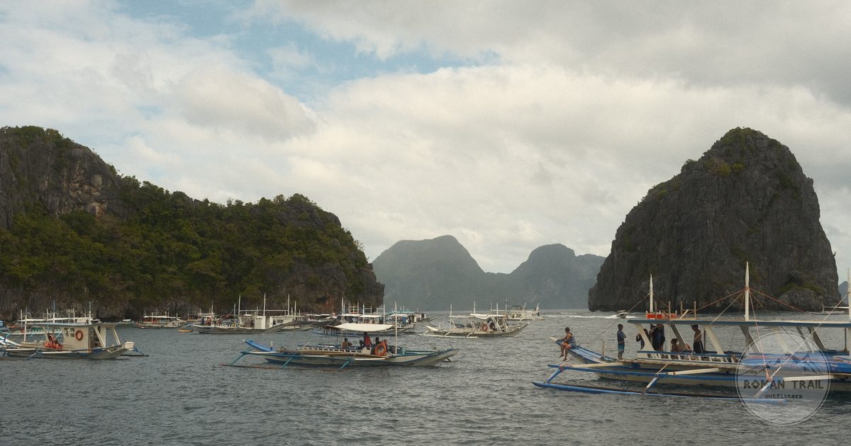 Traditional bancas moored beside the limestone cliffs of El Nido, Palawan
