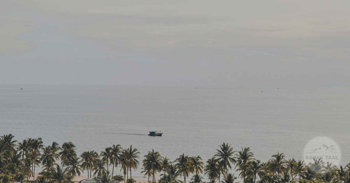 A palm lined beach with a boat offshore on Phu Quoc, Vietnam