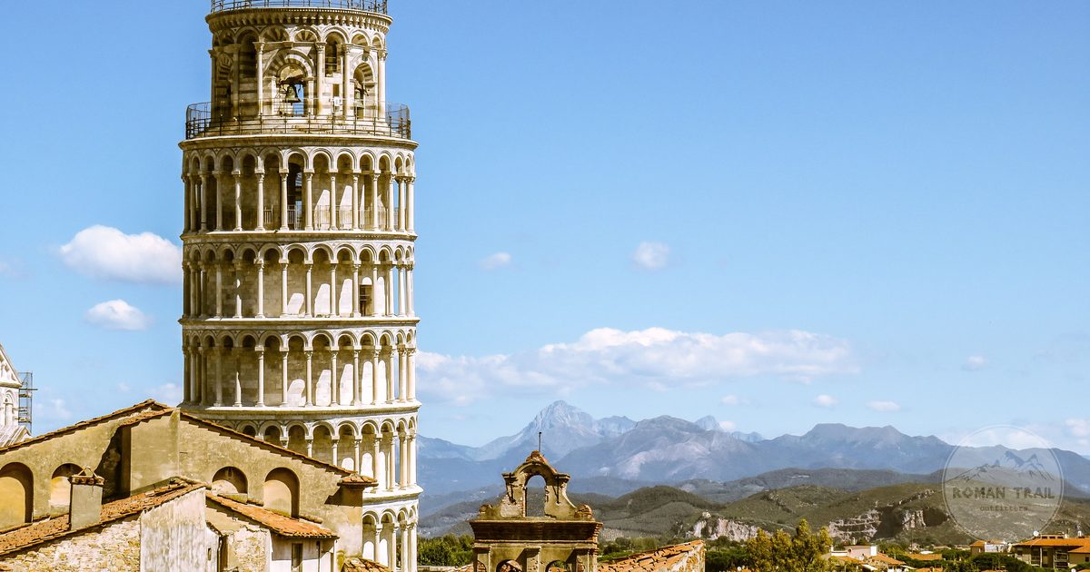 The Leaning Tower of Pisa framed by rooftops and distant mountains, Italy