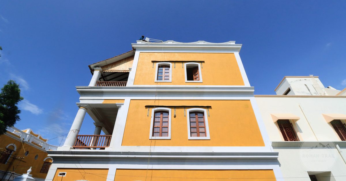 A yellow colonial building with tall columns in Puducherry, India