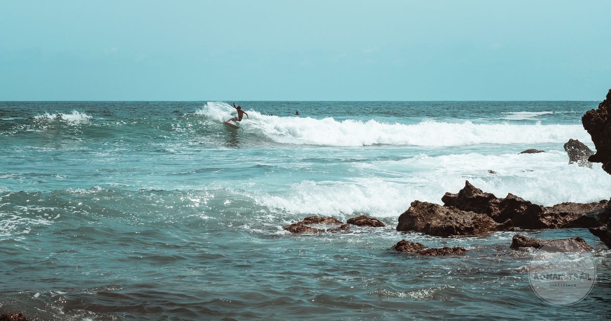 A surfer riding a wave on the rocky coastline at Puerto Escondido, Mexico