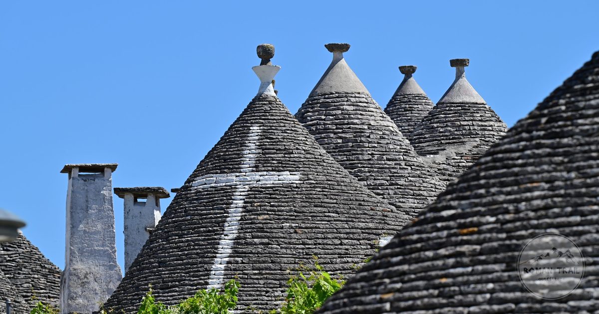 Trulli houses with conical roofs against a clear sky, Alberobello