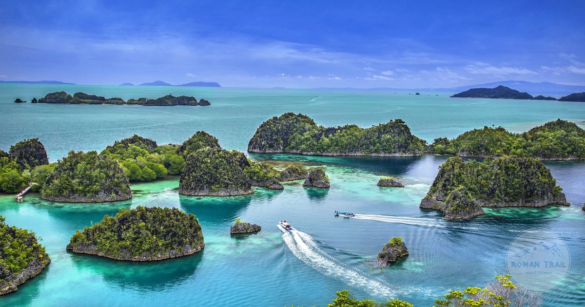 Green limestone islands scattered across shallow water in Papua, Raja Ampat packing list for women by Roman Trail Outfitters