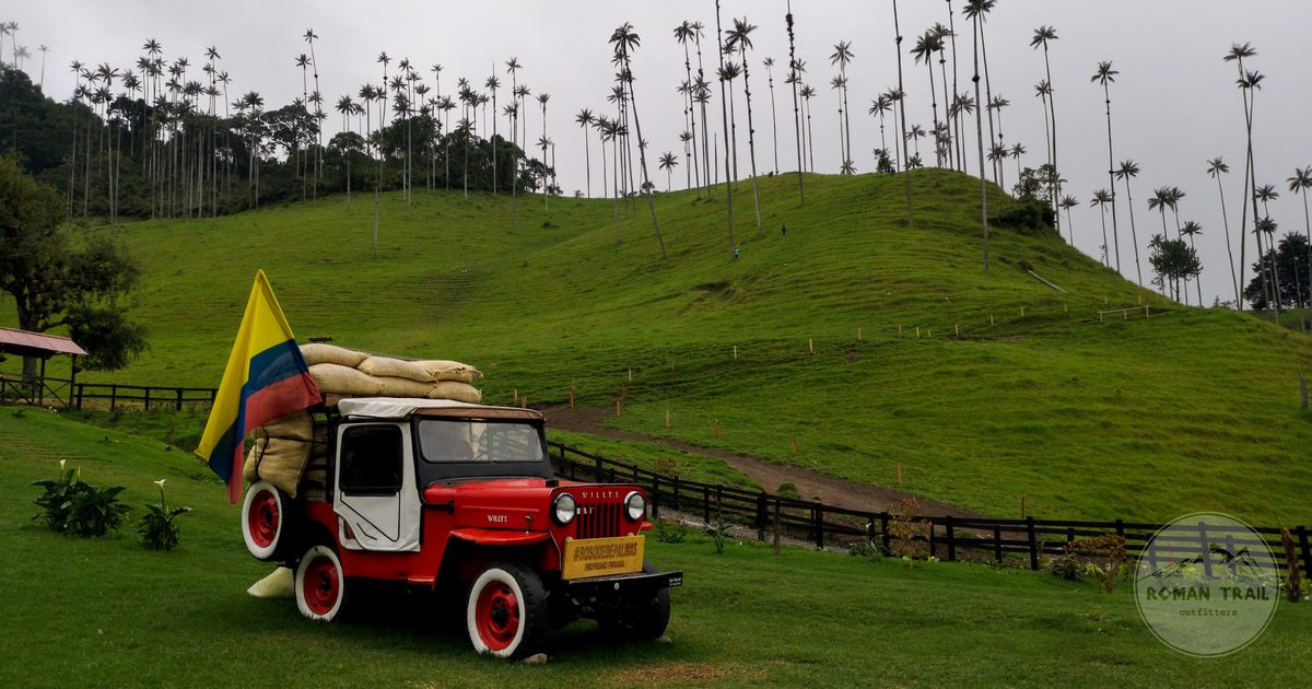 A vintage jeep with a Colombian flag in the hills at Salento, Colombia