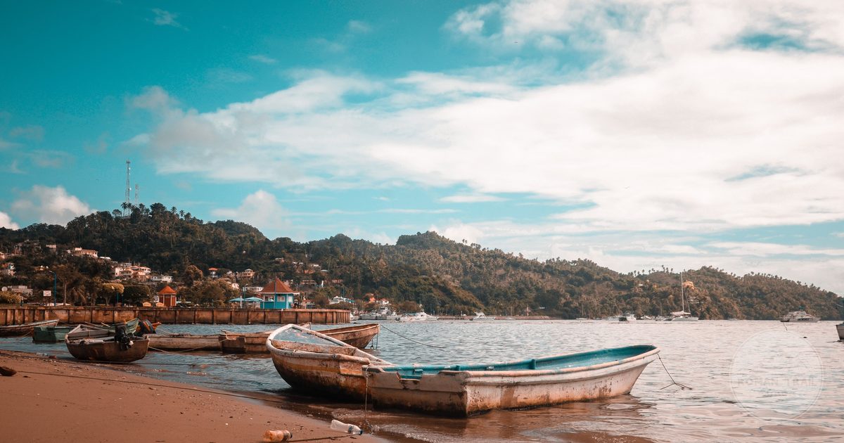 Fishing boats on a beach at Samaná, Dominican Republic, under a bright sky