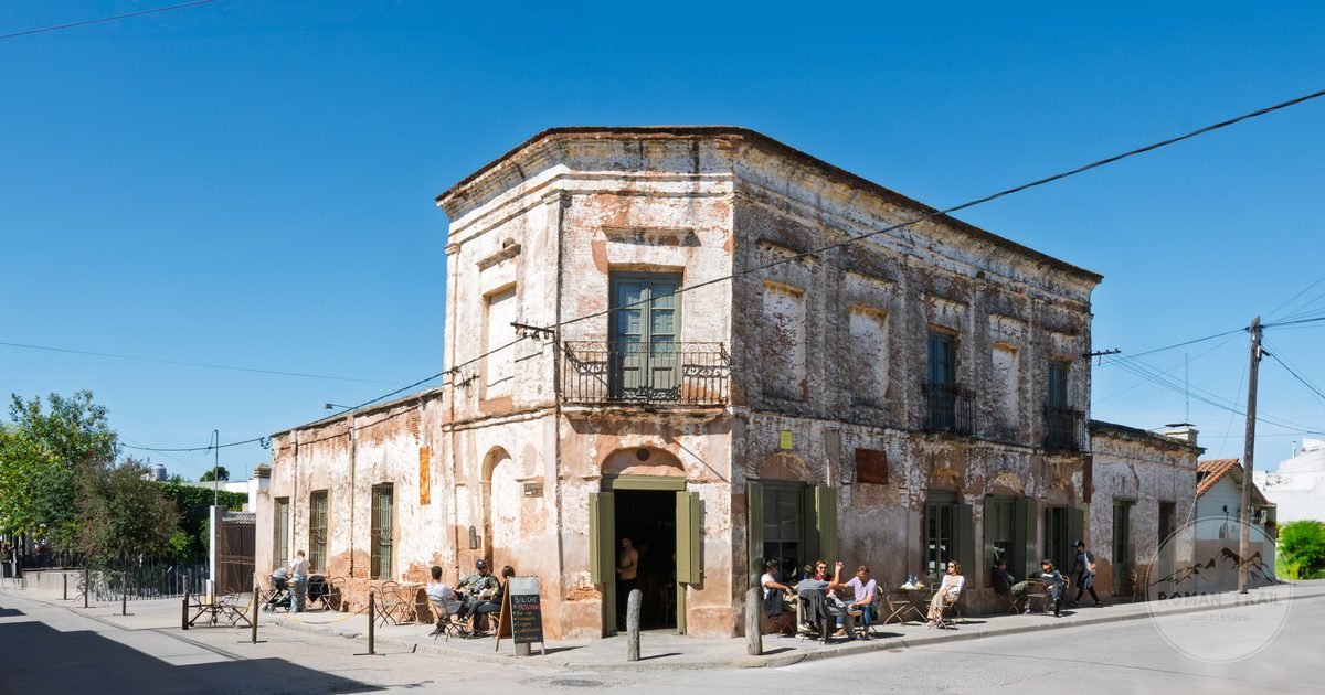 People outside a historic building on a sunny day in San Antonio de Areco, Argentina