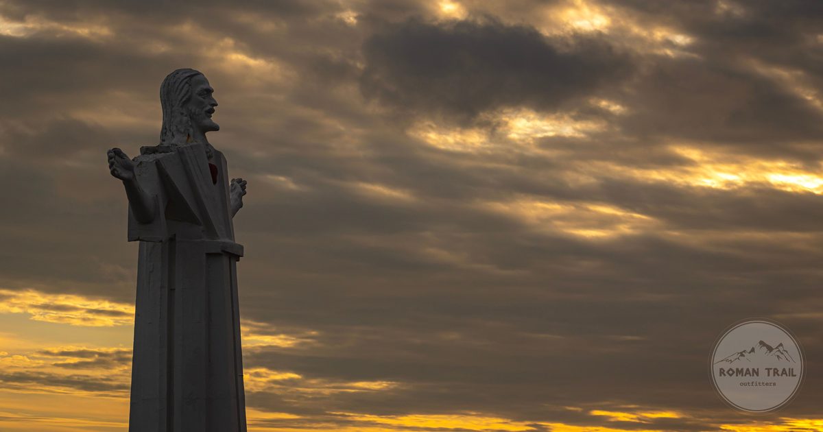 The Divine Savior of the World monument in silhouette against a sunset sky