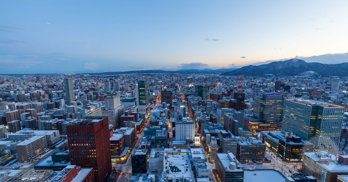 Aerial view of Sapporo under snow at dusk with the Hokkaido mountains beyond, Sapporo packing list for women by Roman Trail Outfitters