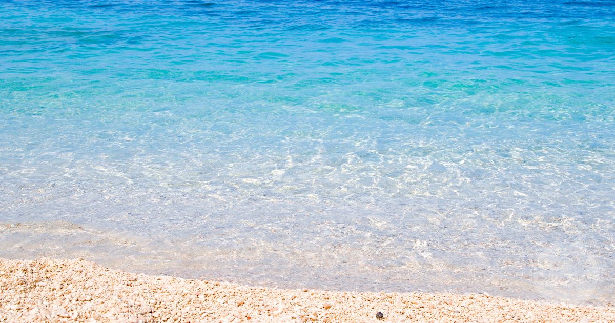 Crystal clear water and sand on a beach in Sardinia, Italy