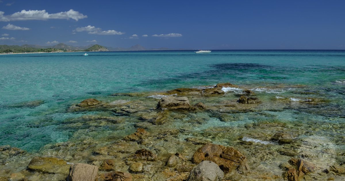 Clear turquoise water and rocky shores on a Sardinian beach