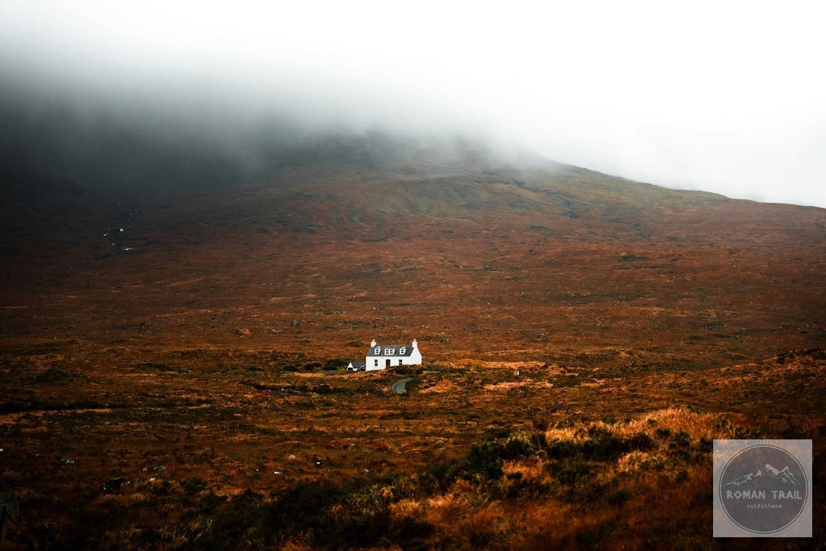 Scottish Highland landscape with misty hills and white cottage for women travelers
