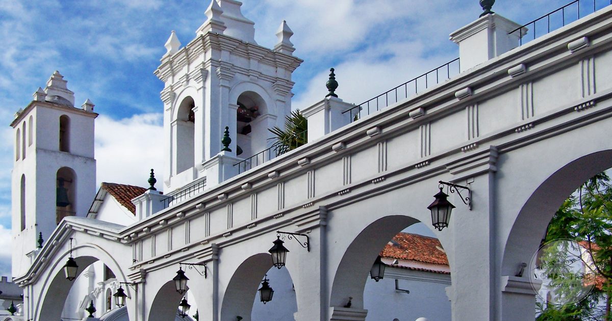 White colonial arches and bell towers against a blue sky in Sucre, Bolivia