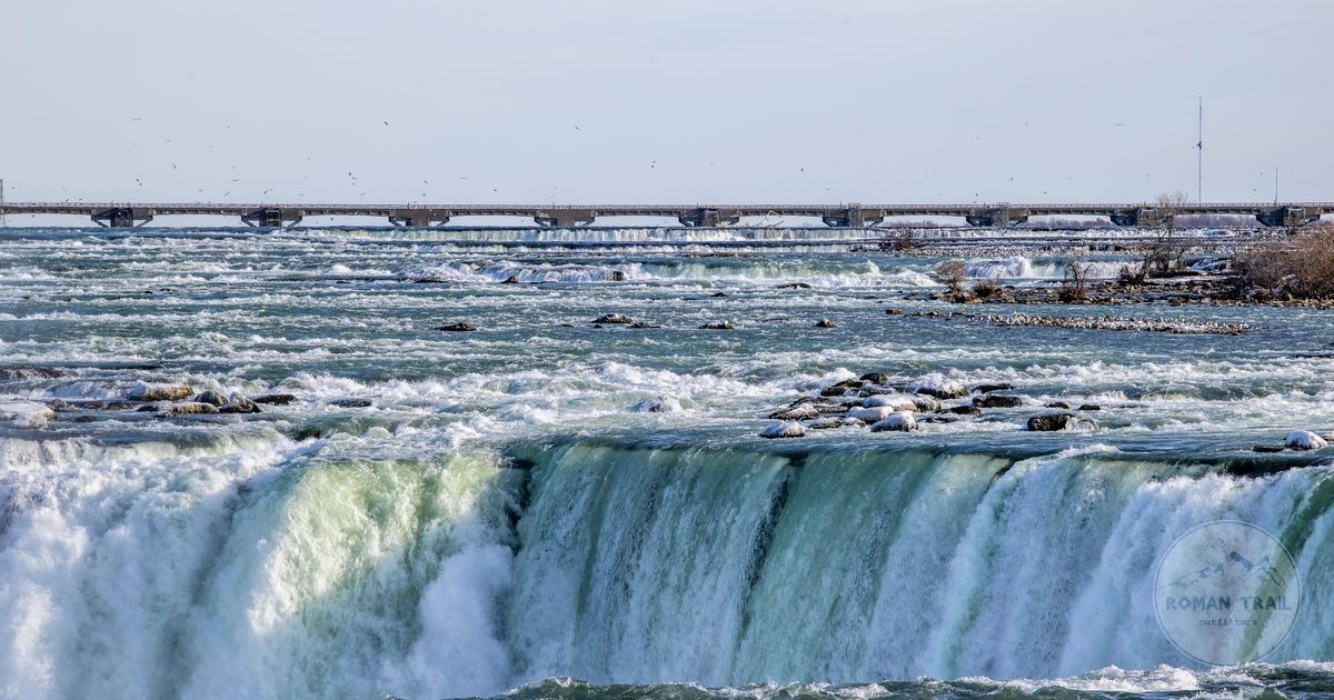 Niagara Falls with cascading water and a distant bridge, Canada