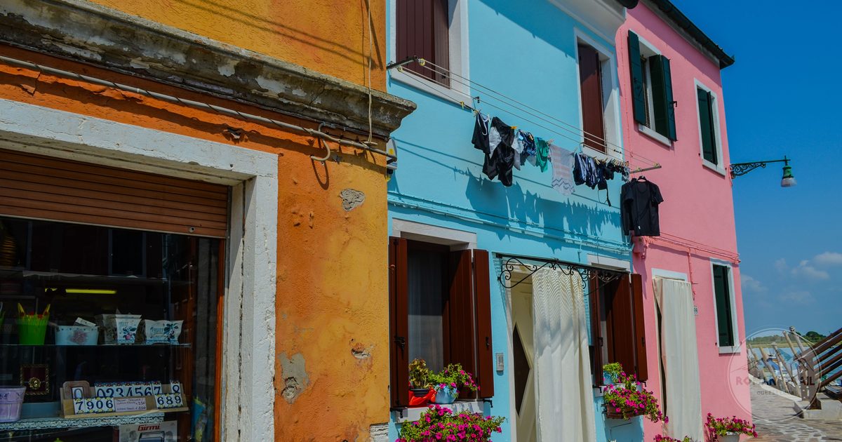 Brightly painted house facades with flower pots in Burano, Venice