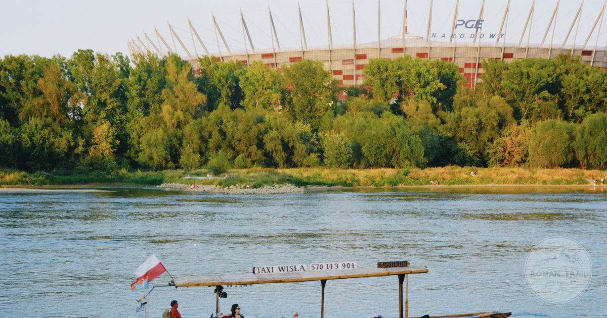 A wooden boat on the Vistula at Warsaw with the National Stadium behind, Poland