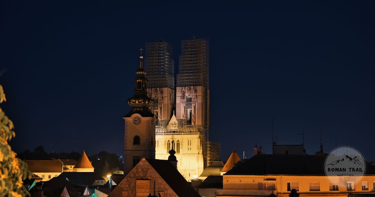 Zagreb Cathedral illuminated at night above the rooftops, Croatia